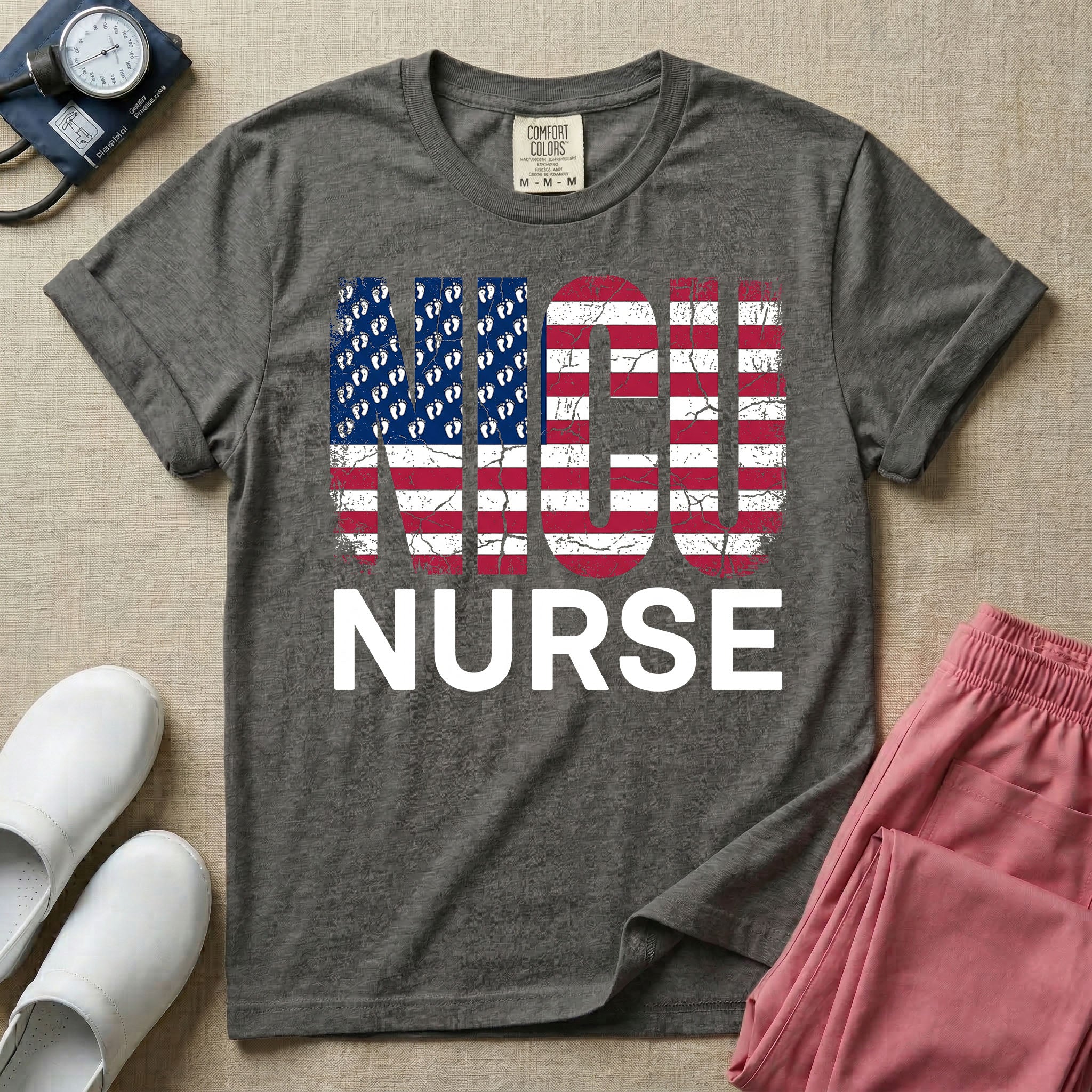 A retro neonatal intensive care unit t-shirt featuring the text "NICU NURSE" with a distressed American flag graphic inside the letters, replacing the traditional stars with tiny white baby footprints.