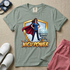 A comic book style neonatal intensive care unit t-shirt featuring an illustration of a confident female nurse wearing a red superhero cape and mask, standing next to an infant incubator inside a golden shield, with the bold text "NICU POWER" below.