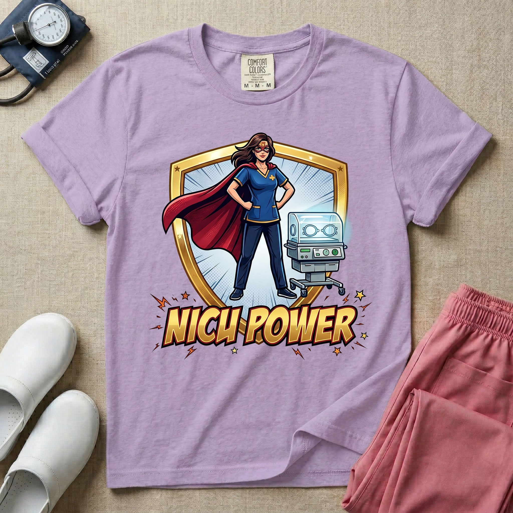 A comic book style neonatal intensive care unit t-shirt featuring an illustration of a confident female nurse wearing a red superhero cape and mask, standing next to an infant incubator inside a golden shield, with the bold text "NICU POWER" below.