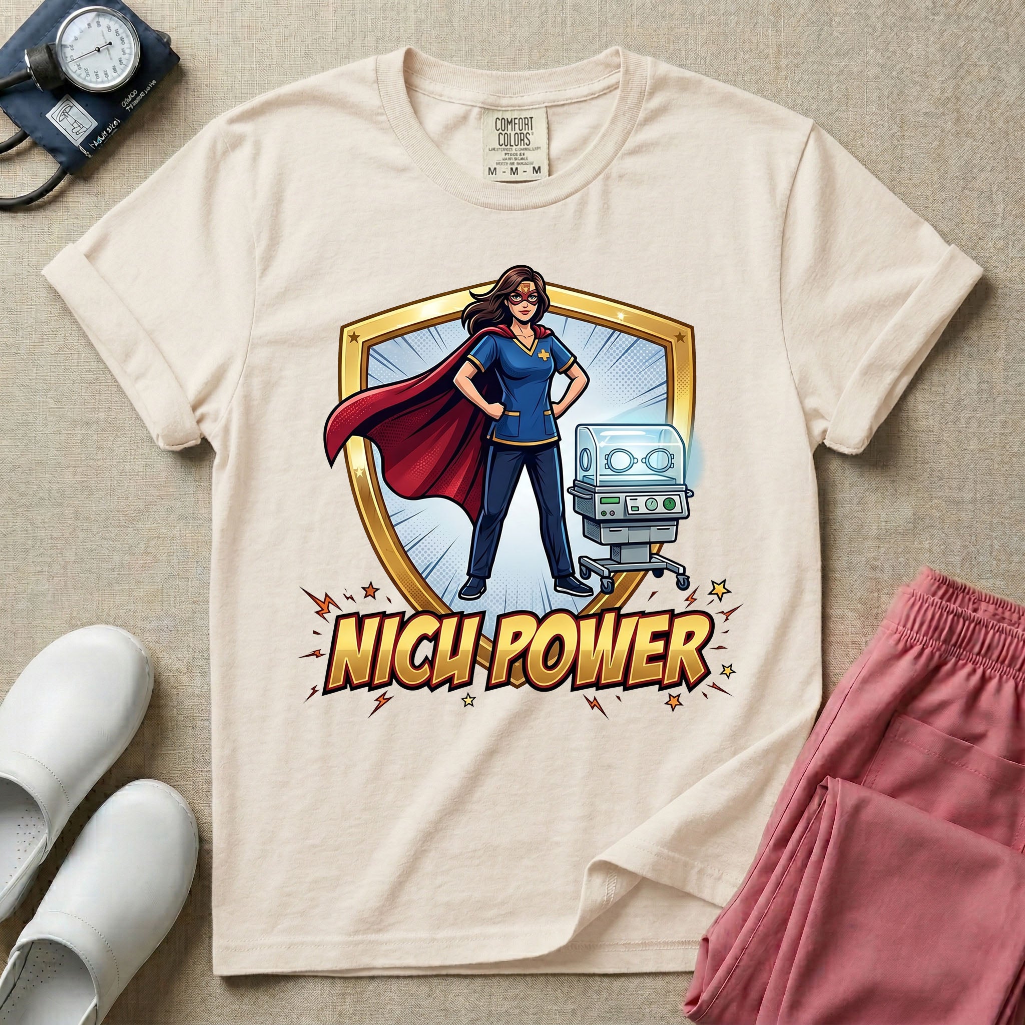 A comic book style neonatal intensive care unit t-shirt featuring an illustration of a confident female nurse wearing a red superhero cape and mask, standing next to an infant incubator inside a golden shield, with the bold text "NICU POWER" below.