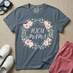 A t-shirt featuring a boho floral wreath composed of pink and cream roses intertwined with a stethoscope, surrounding the text NICU MAMA in elegant typography.