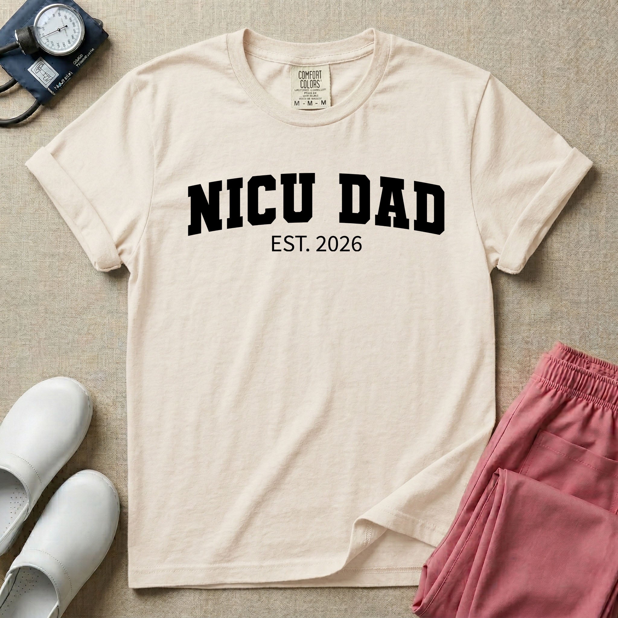 A minimalist personalized t-shirt for the NICU unit featuring bold white collegiate varsity lettering that reads NICU DAD arched over the text EST. 2026.