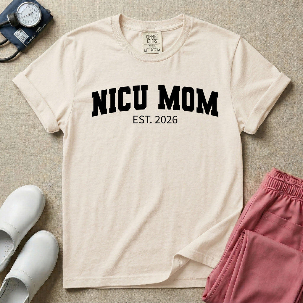 A minimalist personalized t-shirt for the NICU unit featuring bold white collegiate varsity lettering that reads NICU MOM arched over the text EST. 2026.