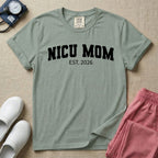 A minimalist personalized t-shirt for the NICU unit featuring bold white collegiate varsity lettering that reads NICU MOM arched over the text EST. 2026.