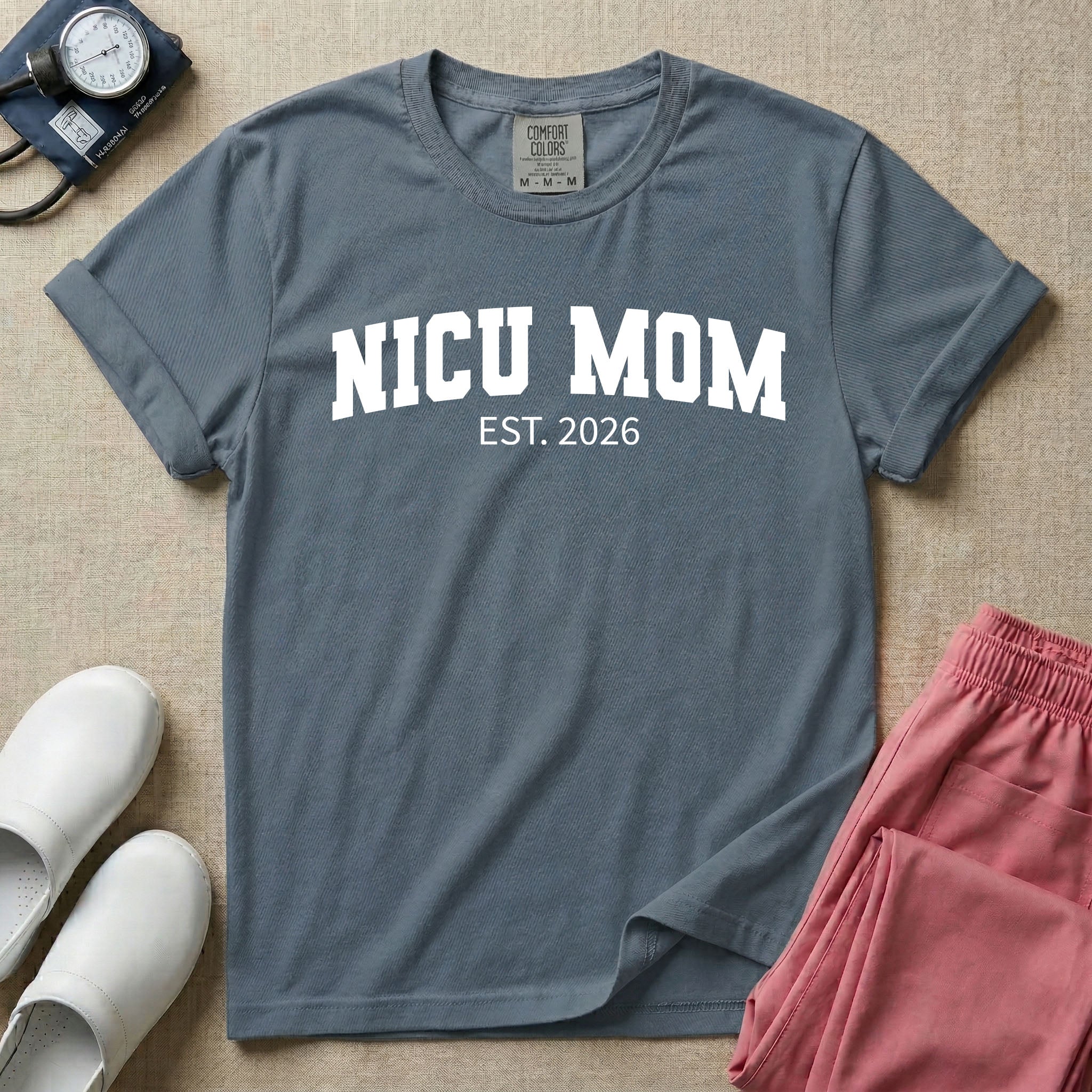 A minimalist personalized t-shirt for the NICU unit featuring bold white collegiate varsity lettering that reads NICU MOM arched over the text EST. 2026.