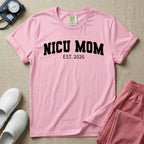 A minimalist personalized t-shirt for the NICU unit featuring bold white collegiate varsity lettering that reads NICU MOM arched over the text EST. 2026.