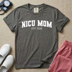 A minimalist personalized t-shirt for the NICU unit featuring bold white collegiate varsity lettering that reads NICU MOM arched over the text EST. 2026.