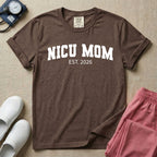 A minimalist personalized t-shirt for the NICU unit featuring bold white collegiate varsity lettering that reads NICU MOM arched over the text EST. 2026.