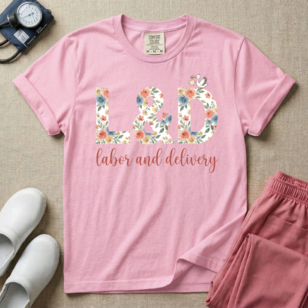 A Labor and Delivery nurse design featuring the large letters L&D filled with a gorgeous boho floral pattern of peach and blue flowers, with a tiny cartoon stork resting on top of the letter D, all positioned above the elegant white script text labor and delivery.