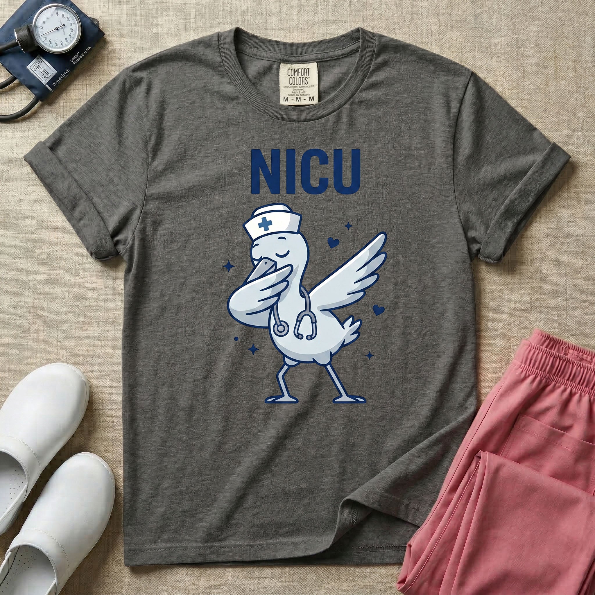 A cute and funny t-shirt design for neonatal intensive care unit nurses featuring a cartoon stork wearing a stethoscope and nurse hat while performing a dabbing dance pose beneath bold letters that read NICU.