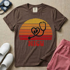 Retro vintage graphic featuring a distressed sunset background with a heart-shaped stethoscope enclosing tiny baby footprints above the bold text NICU.
