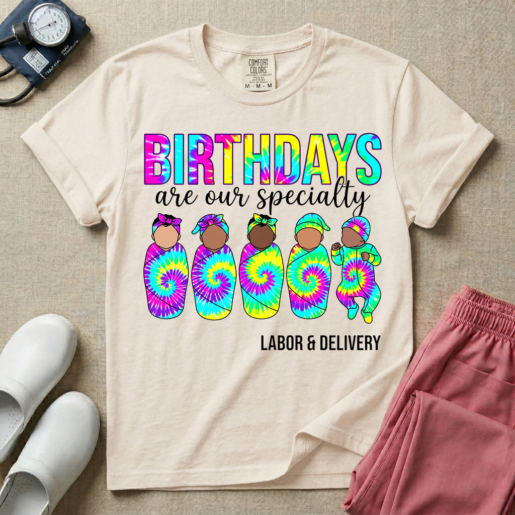 Labor and Delivery nurse design featuring the text Birthdays Are Our Specialty above five cute newborn babies wrapped in colorful tie-dye swaddles and matching hats.
