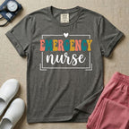 Retro Emergency Room nurse design featuring groovy multi-color block lettering spelling Emergency and white script text reading nurse within a minimalist heart-accented frame.