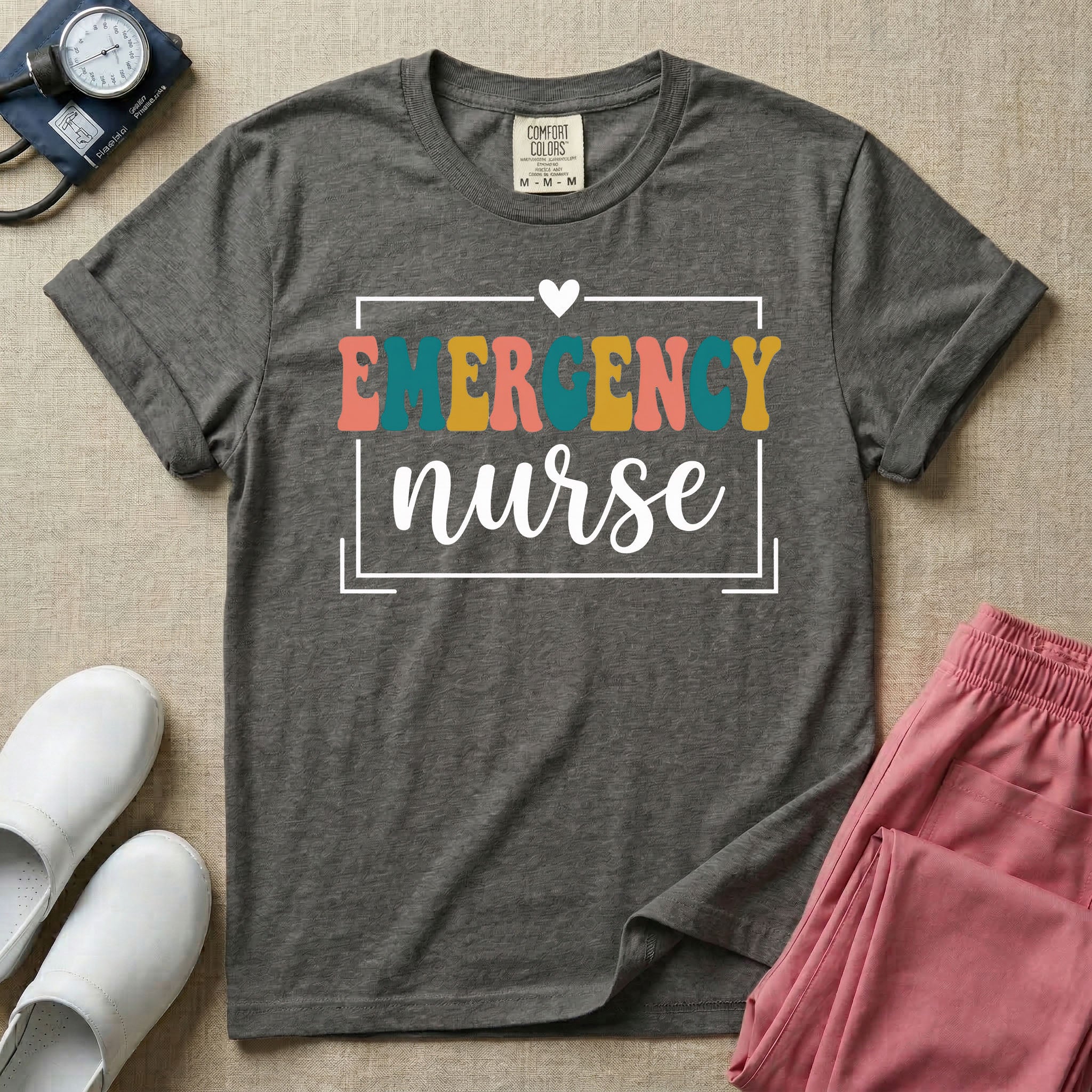 Retro Emergency Room nurse design featuring groovy multi-color block lettering spelling Emergency and white script text reading nurse within a minimalist heart-accented frame.