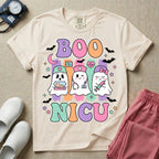 Cute Halloween NICU nurse design featuring the text Boo NICU in retro bubble letters with three ghost nurses holding an incubator baby, stethoscope, and syringe surrounded by flying bats and pastel stars.