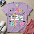 Cute Halloween NICU nurse design featuring the text Boo NICU in retro bubble letters with three ghost nurses holding an incubator baby, stethoscope, and syringe surrounded by flying bats and pastel stars.