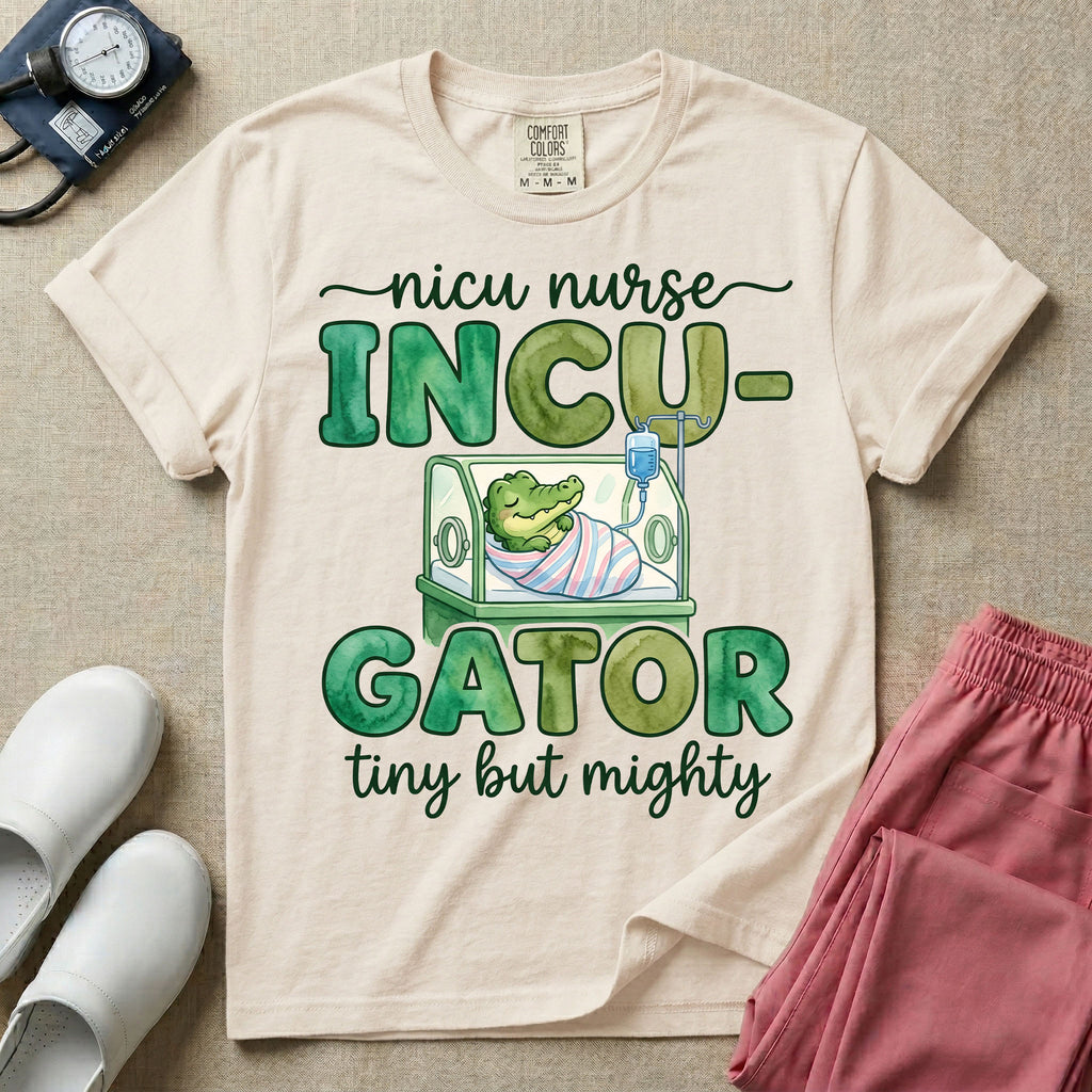 Cute and funny NICU nurse design featuring the text Incu-Gator Tiny But Mighty with an adorable baby alligator swaddled in a hospital receiving blanket resting inside an incubator isolette.
