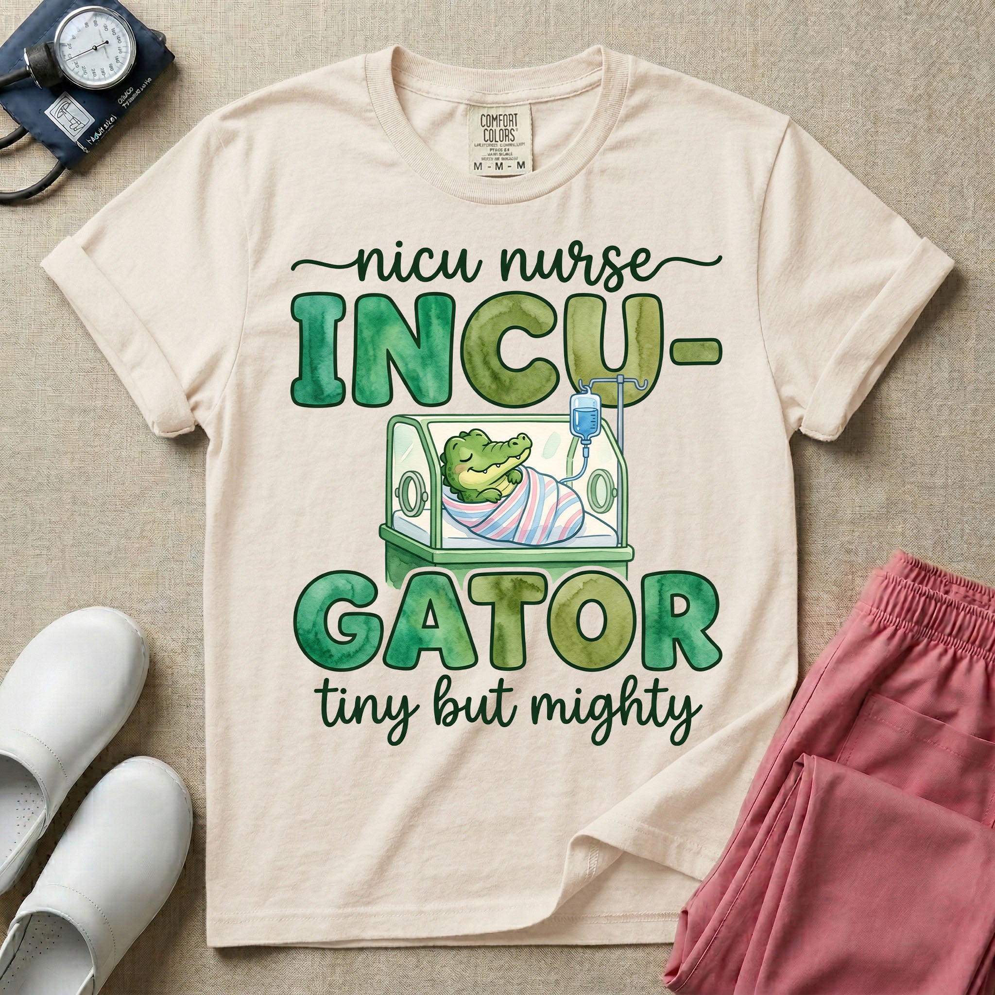 Cute and funny NICU nurse design featuring the text Incu-Gator Tiny But Mighty with an adorable baby alligator swaddled in a hospital receiving blanket resting inside an incubator isolette.