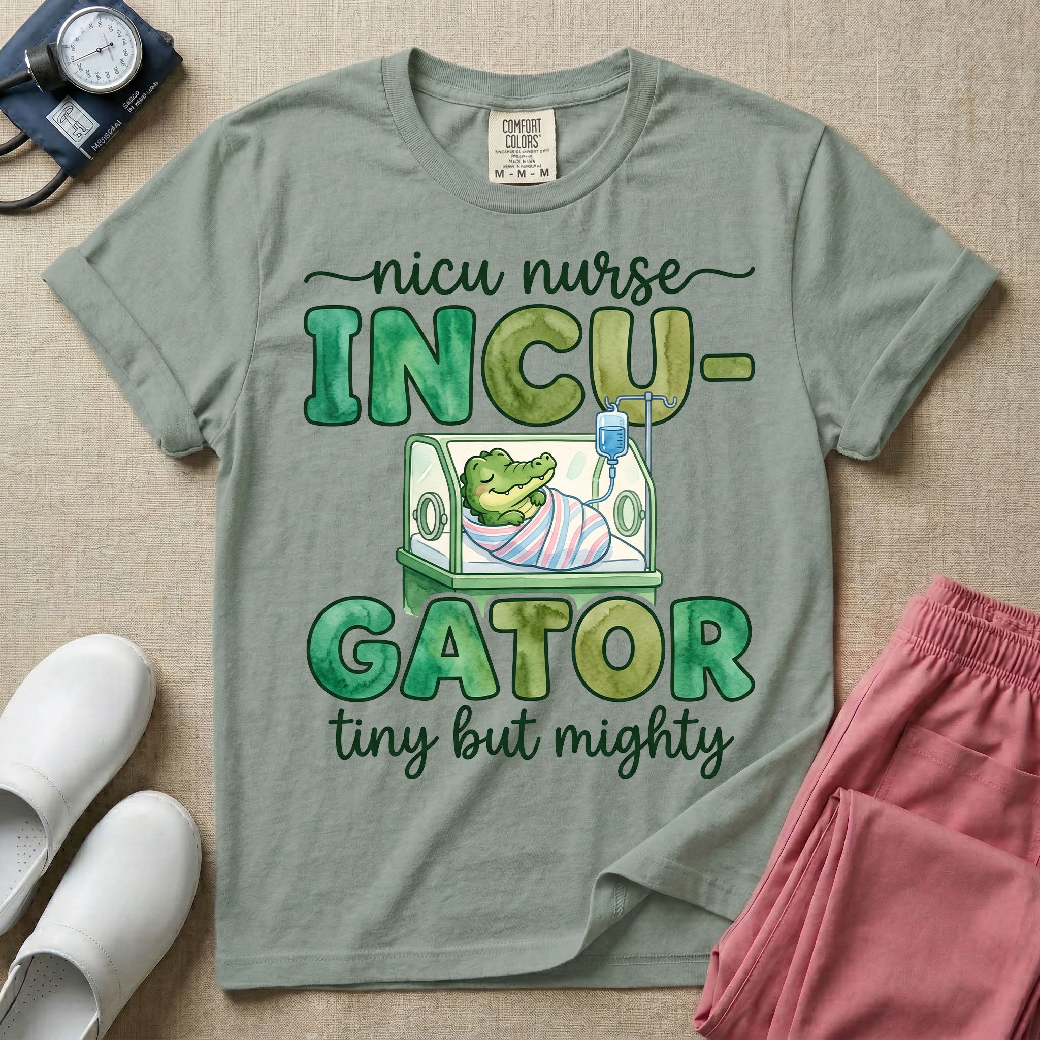 Cute and funny NICU nurse design featuring the text Incu-Gator Tiny But Mighty with an adorable baby alligator swaddled in a hospital receiving blanket resting inside an incubator isolette.