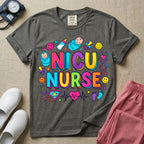 Cute retro NICU nurse design featuring colorful bubble lettering spelling NICU Nurse surrounded by swaddled babies, happy smiley faces, a baby bottle, pacifiers, heart stethoscopes, and an EKG heartbeat pulse graphic.