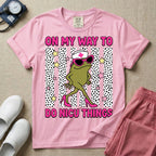 Funny NICU nurse design featuring the text On My Way To Do NICU Things with a sassy frog wearing high heels, sunglasses, and a nurse cap strutting across spotted vertical stripes and stars.