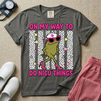Funny NICU nurse design featuring the text On My Way To Do NICU Things with a sassy frog wearing high heels, sunglasses, and a nurse cap strutting across spotted vertical stripes and stars.