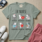 A funny t-shirt for emergency room nurses featuring the text "ER NURSE" above a grid of six cute cartoon cats demonstrating medical puns, including a cat reading for "PAWTHOLOGY", a cat with an ECG heart for "MEOWTABOLISM", a cat holding a test tube for "LAB PAWNELS", a cat with pills for "MEOWDICATION", a cat holding a heart for "HEALING PAWS", and a cat with a stethoscope for "PURRCEDURES".