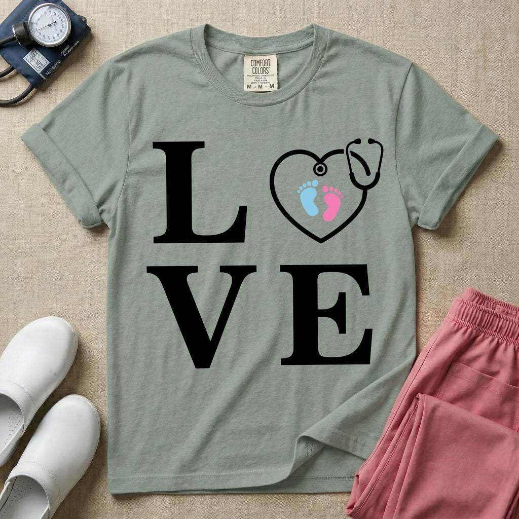 A minimalist nursing t-shirt featuring the word LOVE stacked in large white serif letters, with the letter O replaced by a white stethoscope shaped like a heart containing two small baby footprints, one pink and one blue.