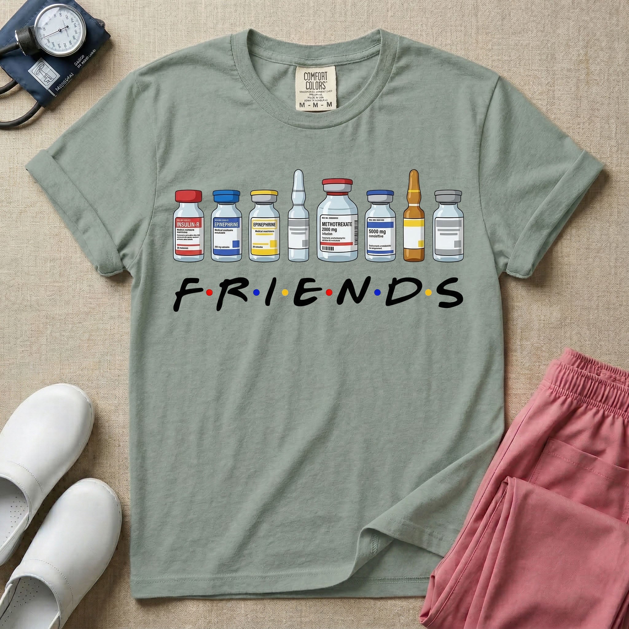 A humorous retro-style t-shirt for nurses featuring a row of seven different medical vials and medicine ampules lined up above the word "FRIENDS", which is styled with colored dots between the letters to resemble the classic television show logo.