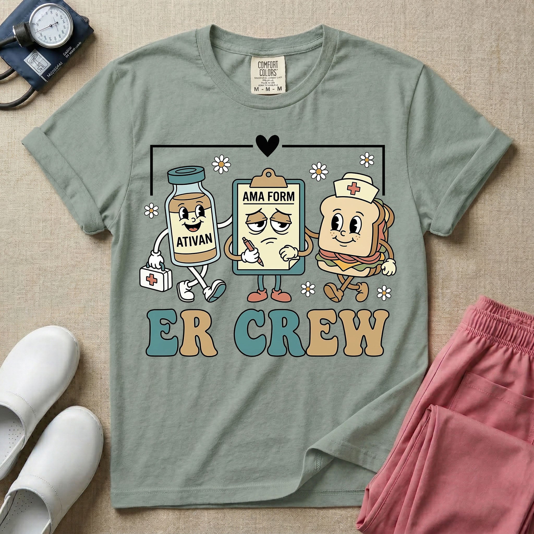 A retro-style t-shirt for emergency room nurses featuring the text "ER CREW" below a vintage cartoon illustration of a medicine bottle, a grumpy clipboard holding an AMA form, and a sandwich wearing a nurse cap walking together.