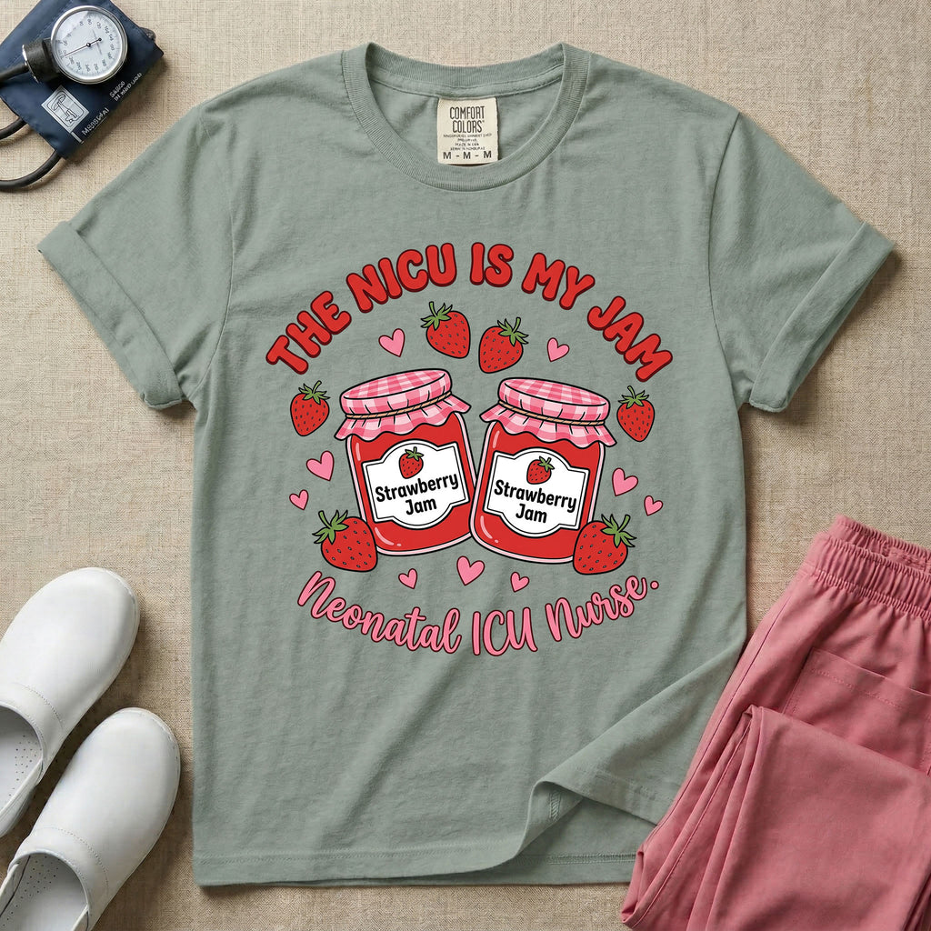 A t-shirt featuring two jars of strawberry jam surrounded by small hearts and strawberries with the text THE NICU IS MY JAM arched above and Neonatal ICU Nurse written in a retro script below.