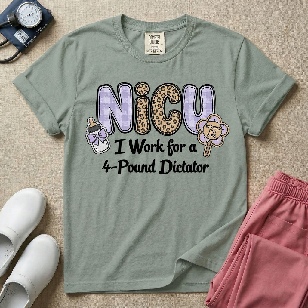 A funny t-shirt for NICU nurses featuring the text "NICU I Work for a 4-Pound Dictator" designed with purple plaid and leopard print letters, accompanied by graphics of a baby bottle with a bow and a rattle that says "WARNING: TINY BOSS".
