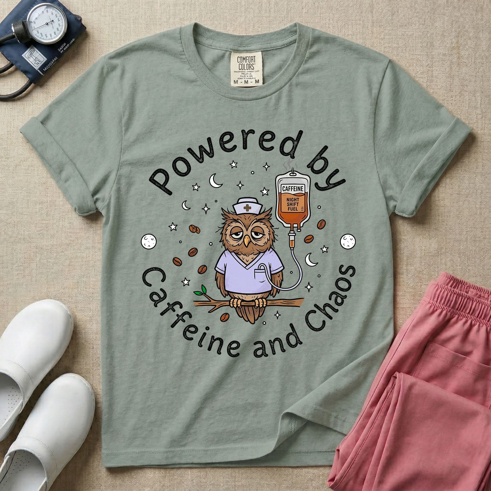 A humorous General Nursing graphic featuring an exhausted owl wearing scrubs and a nurse hat, hooked up to an IV bag labeled CAFFEINE NIGHT SHIFT FUEL, surrounded by coffee beans, stars, and moons, with circular text reading Powered by Caffeine and Chaos.