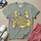 General nursing t-shirt featuring a chaotic group of cartoon ducklings dressed as medical professionals with the text "MOST DEFINITELY NOT ALL IN A ROW" on a sage green garment, in bay color.