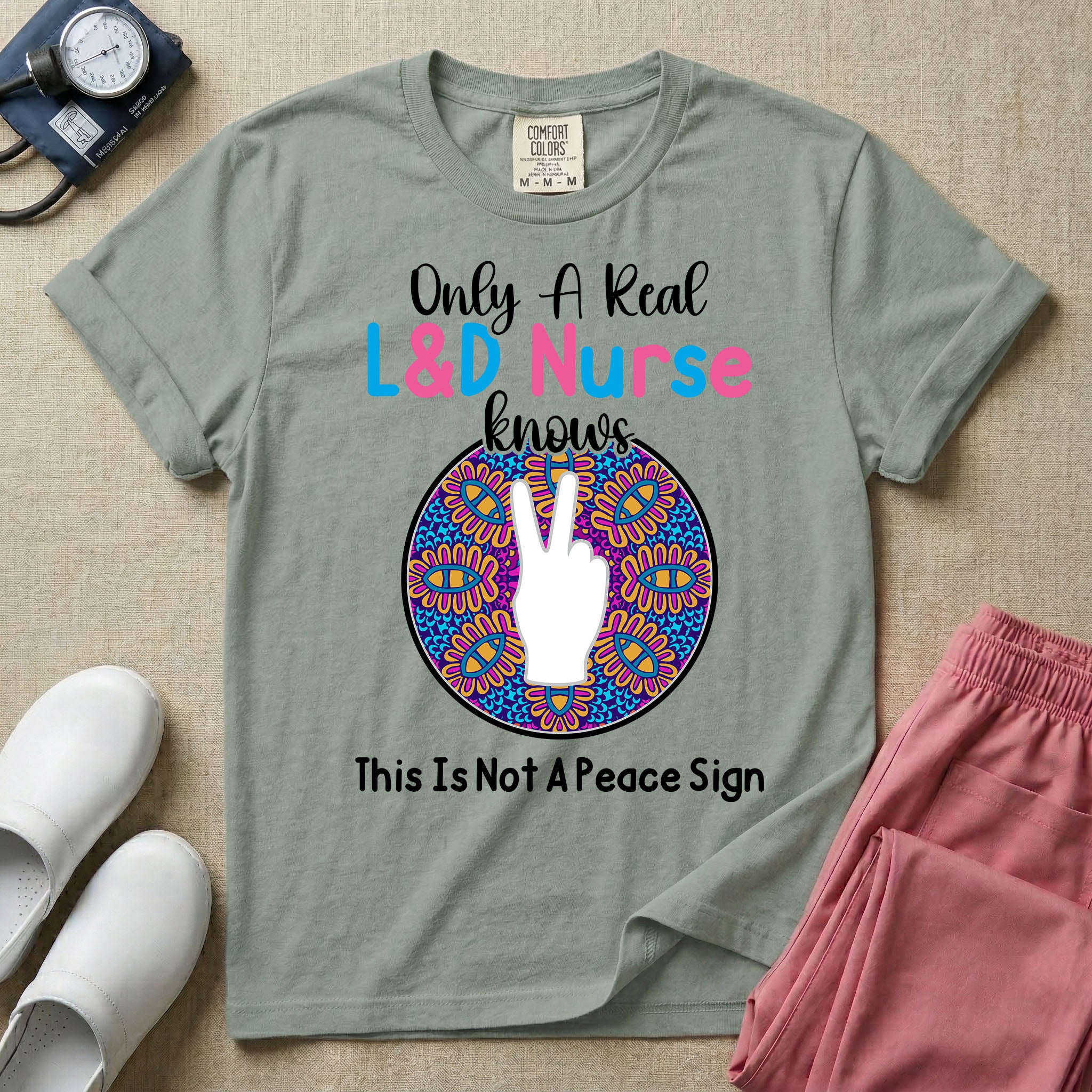 A humorous Labor and Delivery nurse graphic featuring a hand holding up two fingers inside a colorful boho mandala pattern, surrounded by text that reads Only A Real L&D Nurse Knows above and This Is Not A Peace Sign below.