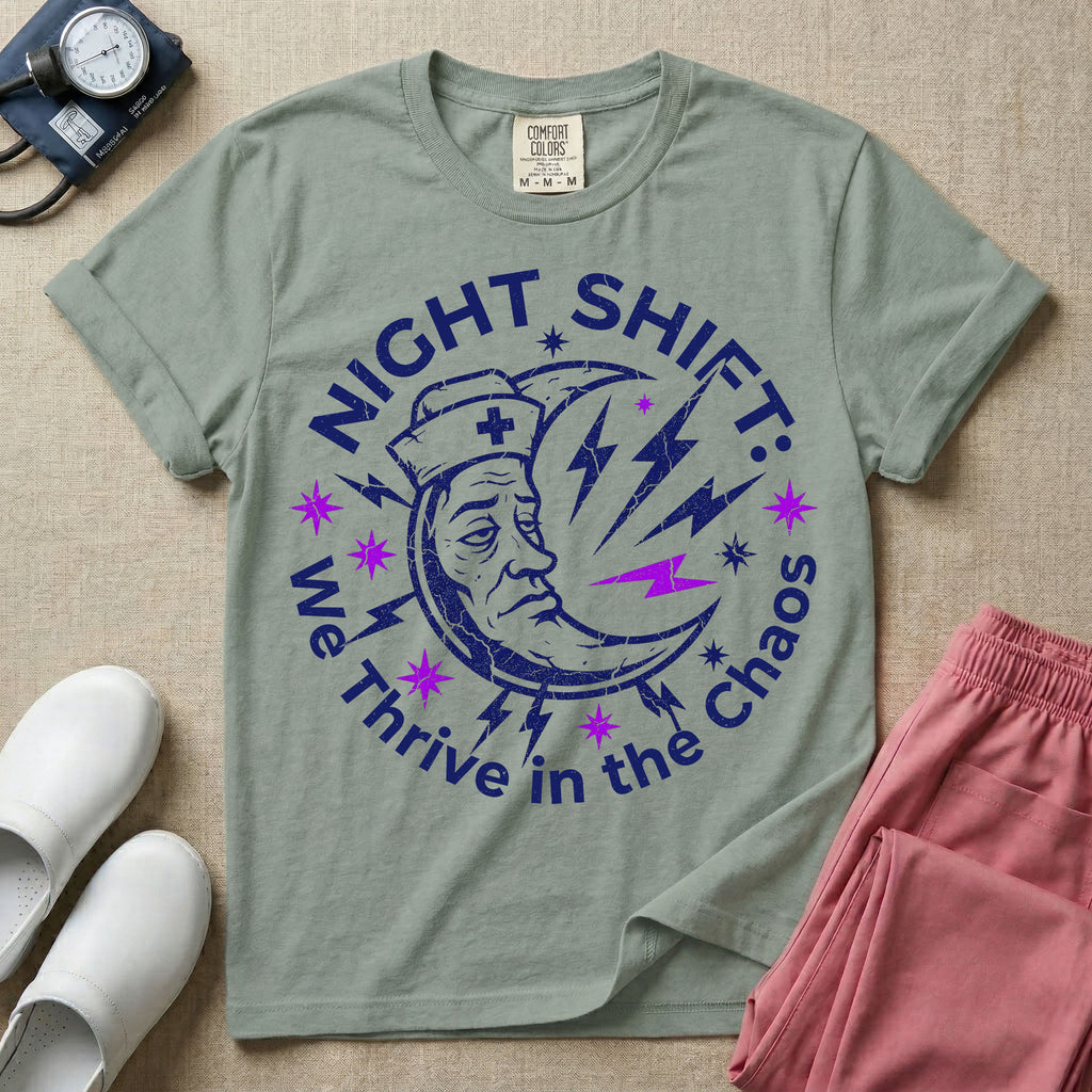 General nursing night shift nurse t-shirt with a retro purple moon wearing a nurse cap and we thrive in the chaos graphic in bay color.
