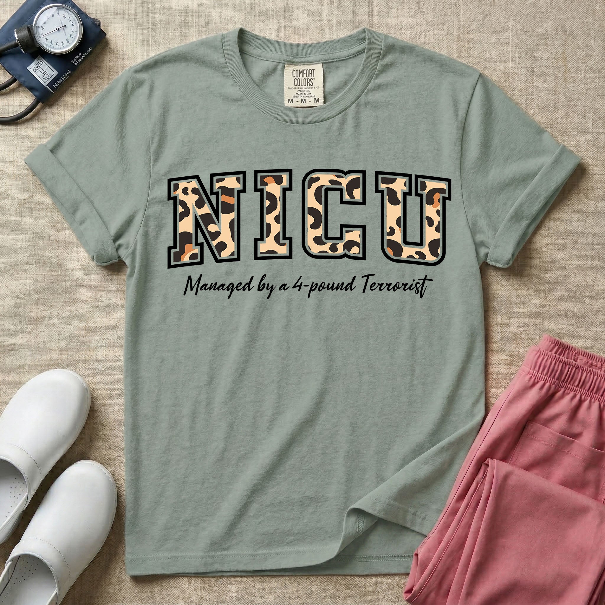 Neonatal Intensive Care Unit NICU nurse t-shirt with leopard print block letters and funny managed by a 4-pound terrorist graphic in bay color.