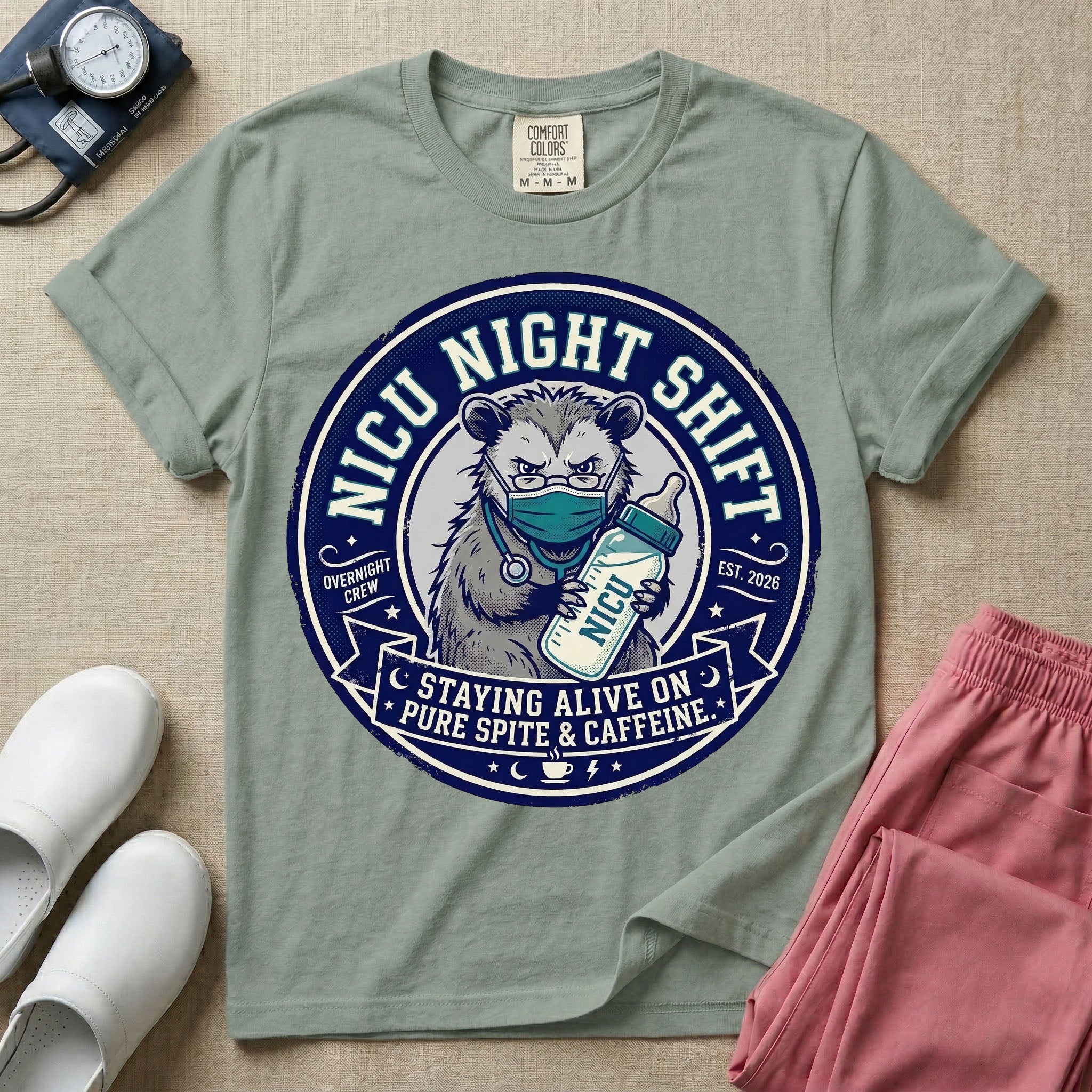 A humorous graphic for a Neonatal Intensive Care Unit featuring a circular design with an illustration of a tired raccoon wearing a medical face mask and holding a baby bottle labeled 'NICU', surrounded by the text 'NICU NIGHT SHIFT' at the top and 'STAYING ALIVE ON PURE SPITE & CAFFEINE' at the bottom.