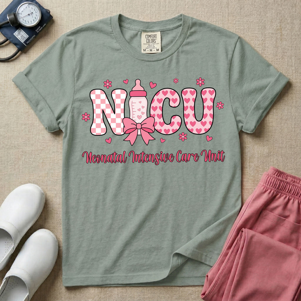 Retro coquette style t-shirt graphic featuring decorative pink 'NICU' text with checkerboard and heart patterns, incorporating a baby bottle with a bow and hearts, and the cursive text 'Neonatal Intensive Care Unit' below.