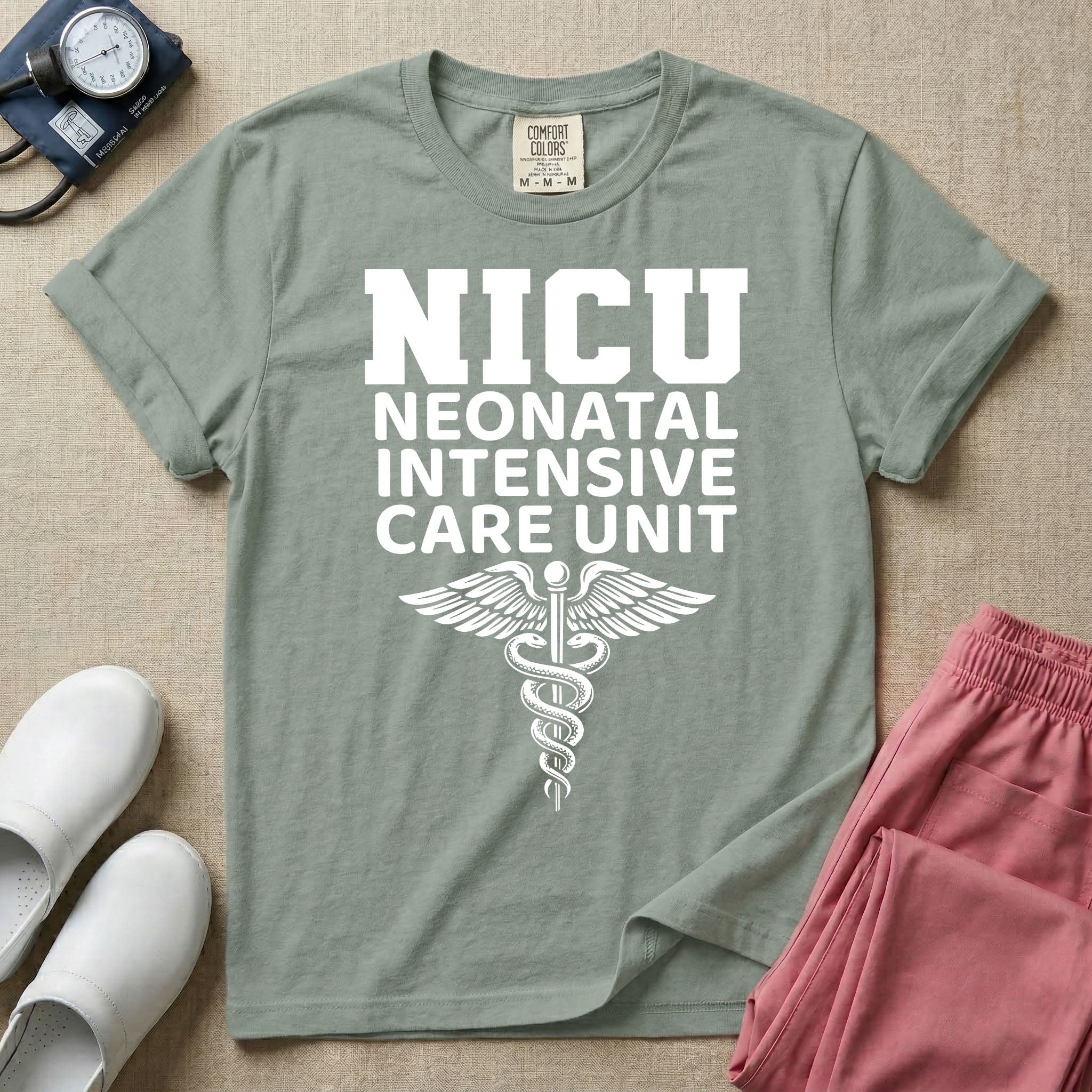 A t-shirt featuring the word NICU in large collegiate block letters above the spelled-out text Neonatal Intensive Care Unit and a medical caduceus symbol.