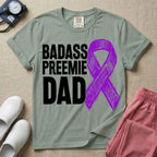 A graphic for the Neonatal Intensive Care Unit featuring the stacked, bold white text 'BADASS PREEMIE DAD' next to a large, textured purple awareness ribbon.