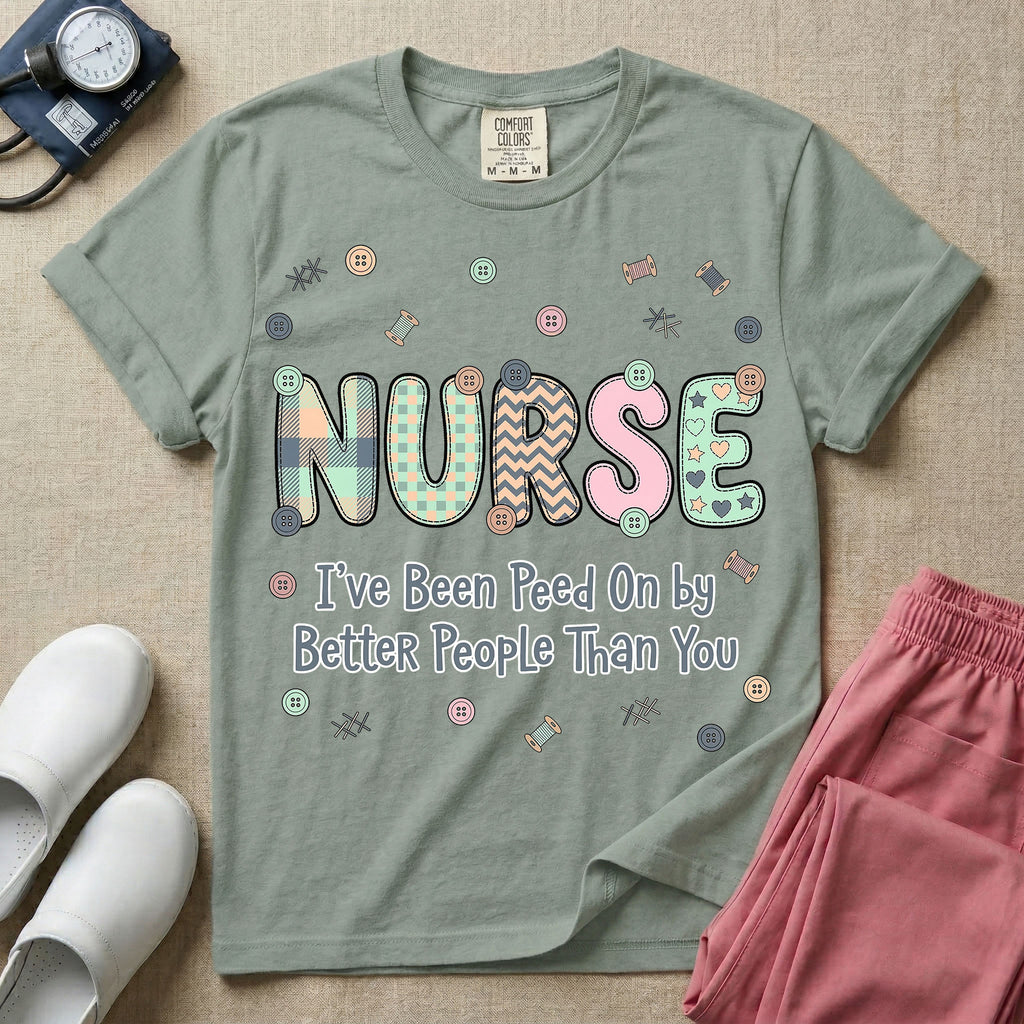 A humorous t-shirt for nurses featuring the word "NURSE" in colorful boho patterned letters above the funny phrase "I've Been Peed On by Better People Than You", surrounded by small abstract floral shapes.
