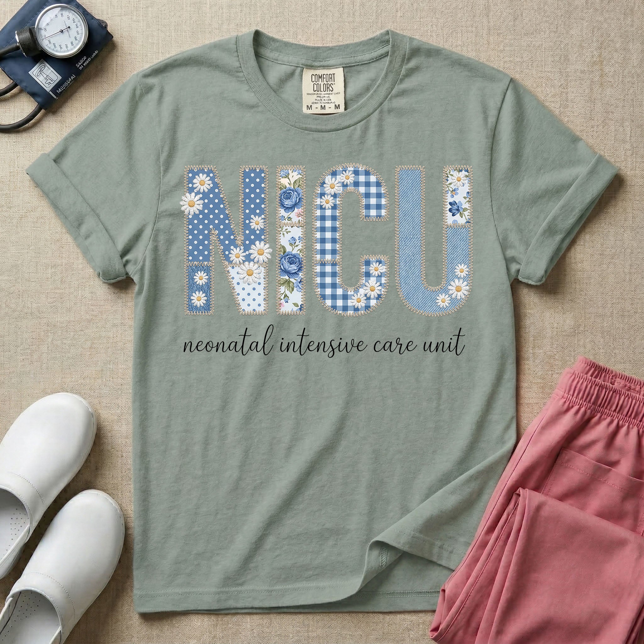 Neonatal Intensive Care Unit NICU nursing t-shirt featuring a faux-embroidery graphic of the letters NICU filled with blue floral and checkered patterns, positioned above the cursive text "neonatal intensive care unit".