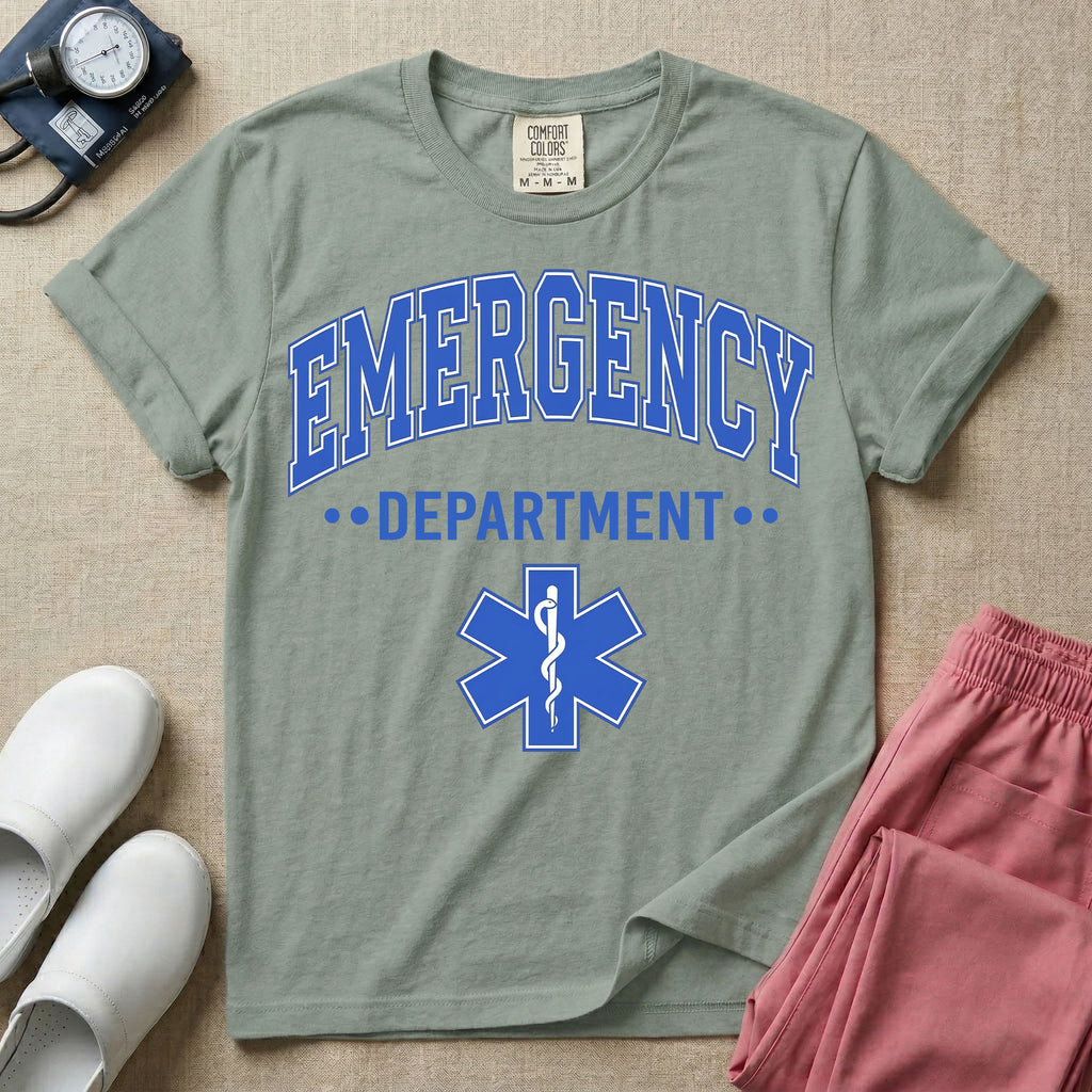 A classic varsity-style t-shirt for emergency room nurses featuring the word "EMERGENCY" in a large, arched blue collegiate font above the word "DEPARTMENT", centered over a blue Star of Life medical symbol.