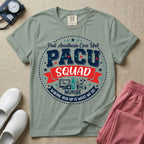 A t-shirt featuring a circular badge design with the text PACU SQUAD in block letters, medical icons like a heart monitor and stethoscope, and the phrase Waking You Up Is What We Do.
