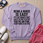 Funny Being A Nurse Is Easy Bike On Fire Sarcastic Nurse Sweatshirt - Orchid Comfort Colors Sweatshirt | HugTee