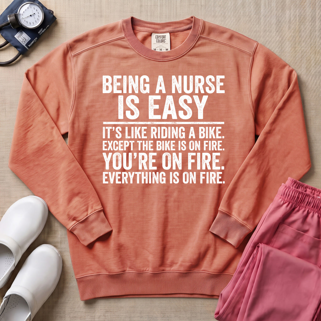 Funny Being A Nurse Is Easy Bike On Fire Sarcastic Nurse Sweatshirt - Terracotta Comfort Colors Sweatshirt | HugTee