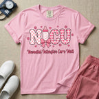 Retro coquette style t-shirt graphic featuring decorative pink 'NICU' text with checkerboard and heart patterns, incorporating a baby bottle with a bow and hearts, and the cursive text 'Neonatal Intensive Care Unit' below.