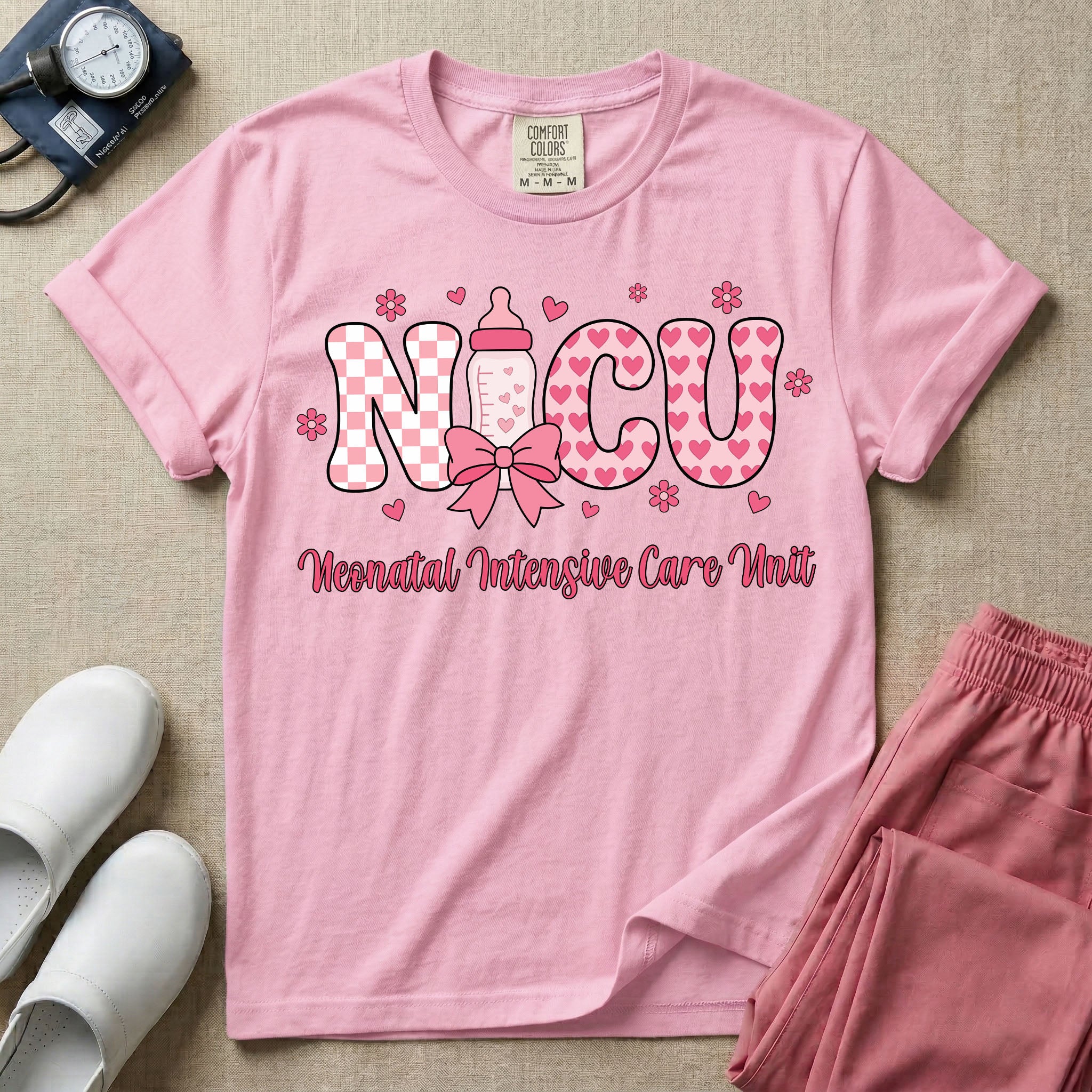Retro coquette style t-shirt graphic featuring decorative pink 'NICU' text with checkerboard and heart patterns, incorporating a baby bottle with a bow and hearts, and the cursive text 'Neonatal Intensive Care Unit' below.