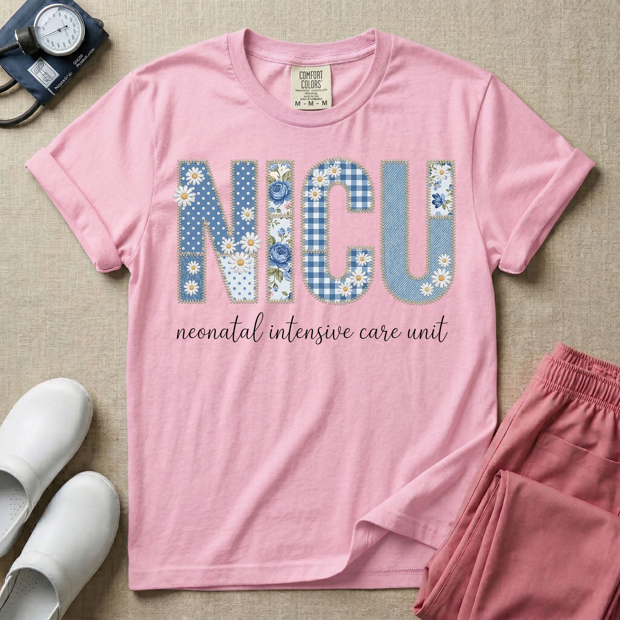 Neonatal Intensive Care Unit NICU nursing t-shirt featuring a faux-embroidery graphic of the letters NICU filled with blue floral and checkered patterns, positioned above the cursive text "neonatal intensive care unit".